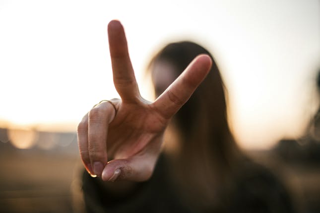 a woman holding up a peace sign