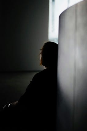 Woman sits looking on