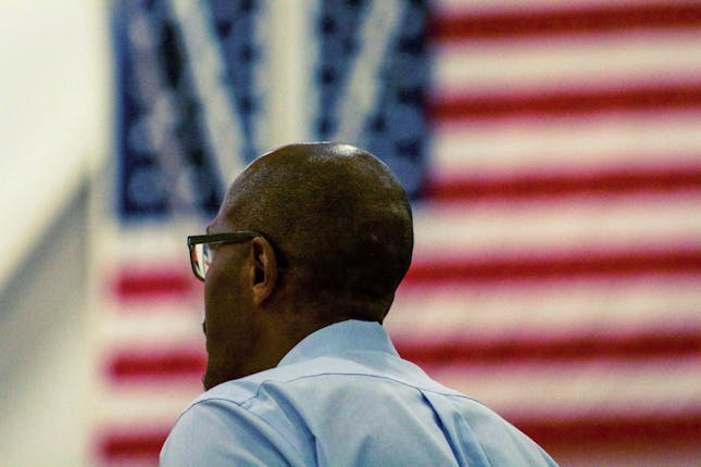 An African-American man in front of a US flag to illustrate that many Americans think of phrases like, “I don’t feel safe in my own country”, due to the amount of racism today.